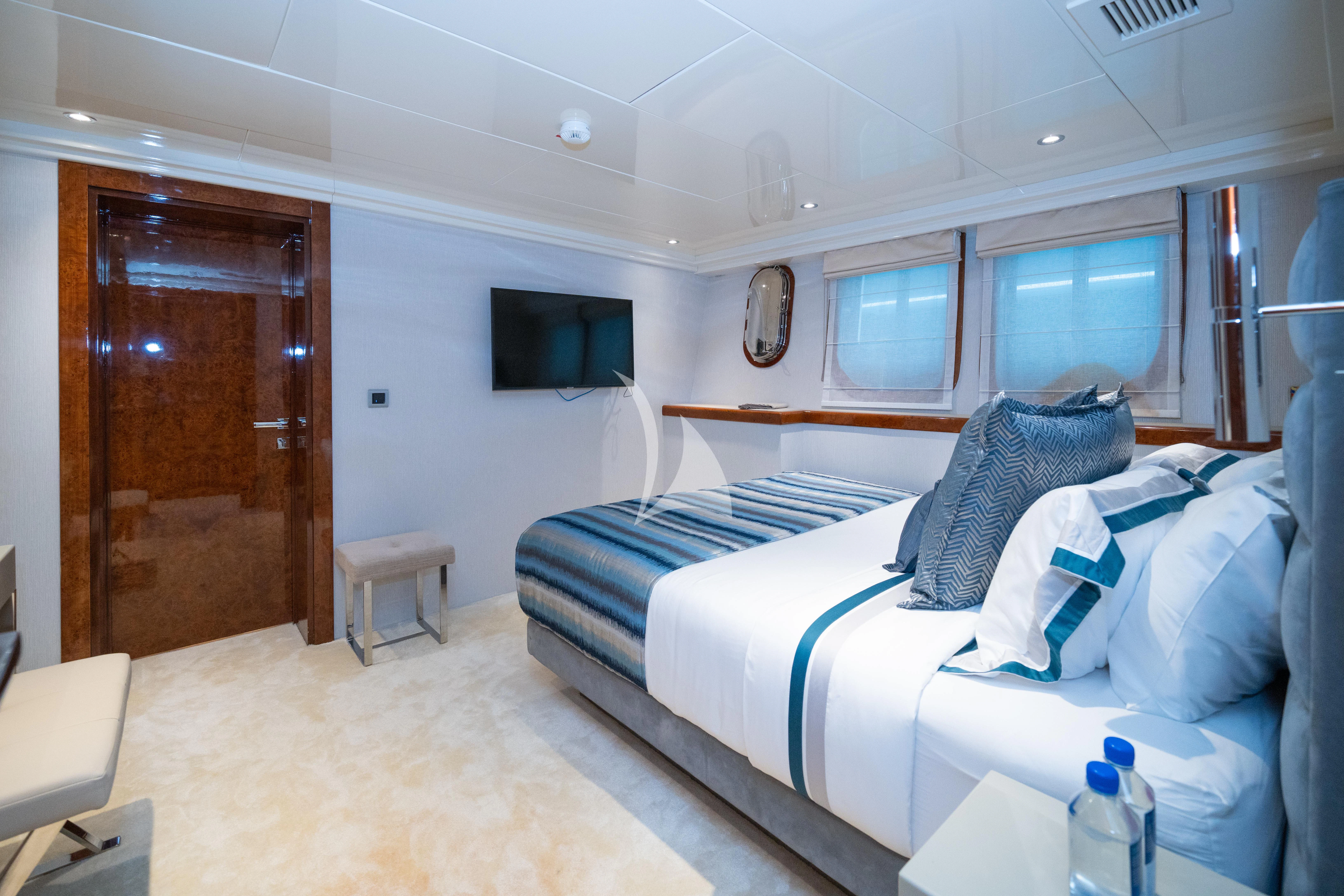 a room with a bed and a television aboard HALLO Yacht for Sale
