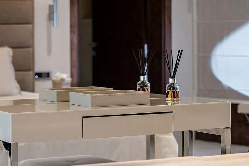 a table with a glass and a vase with sticks in it aboard HALLO Yacht for Sale
