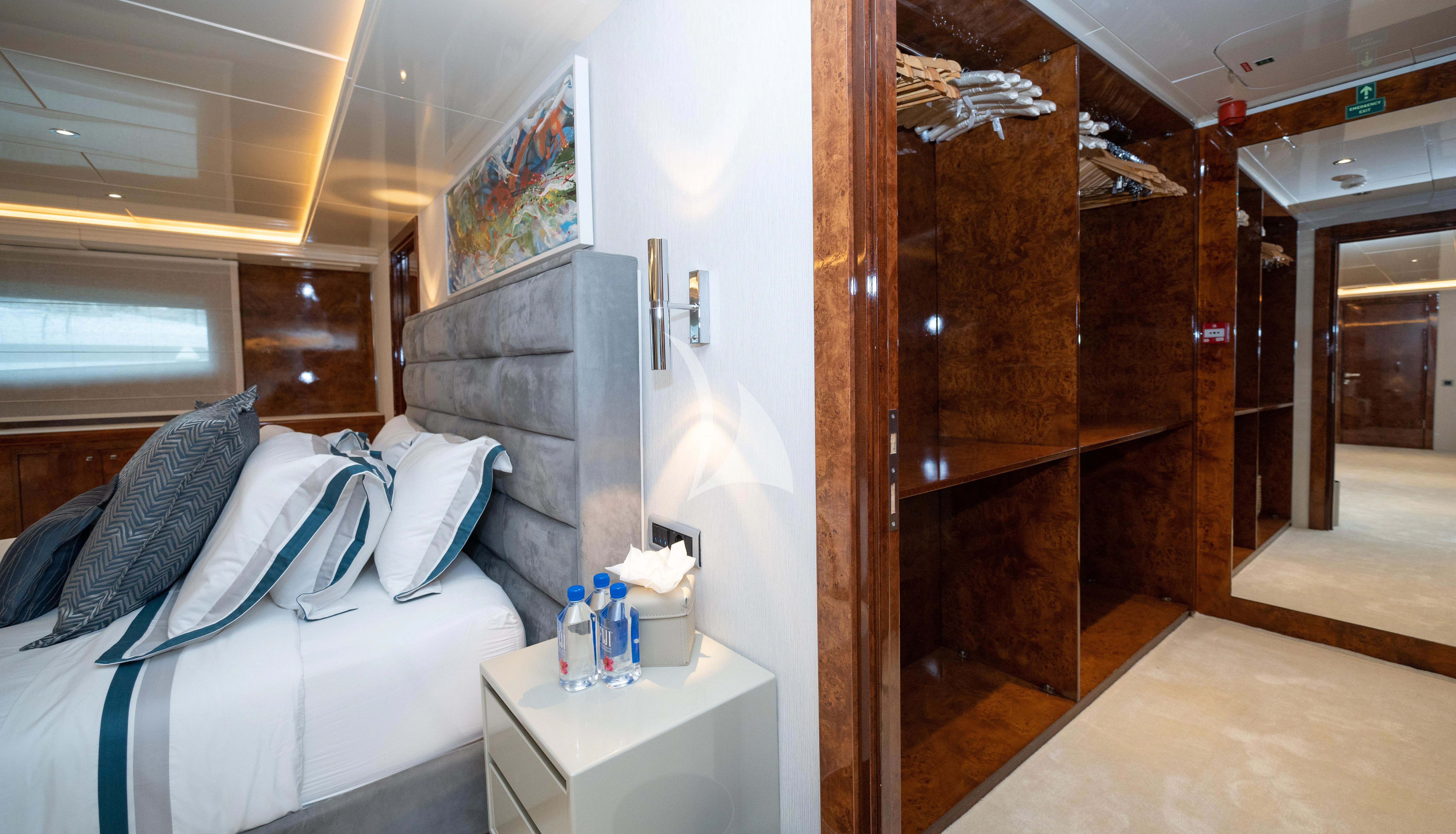 a room with a bed and a wood cabinet aboard HALLO Yacht for Sale