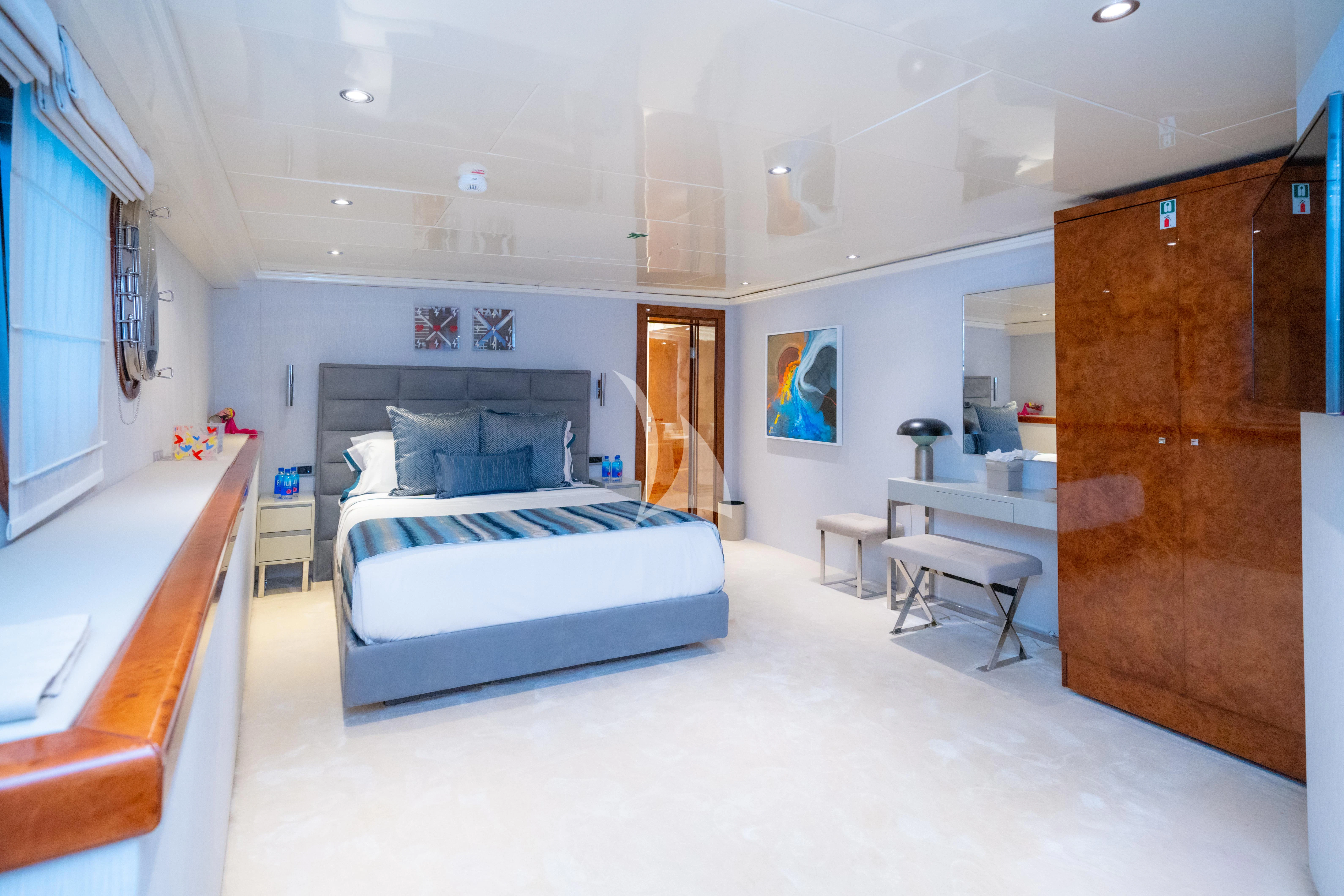 a bedroom with a bed and desk aboard HALLO Yacht for Sale