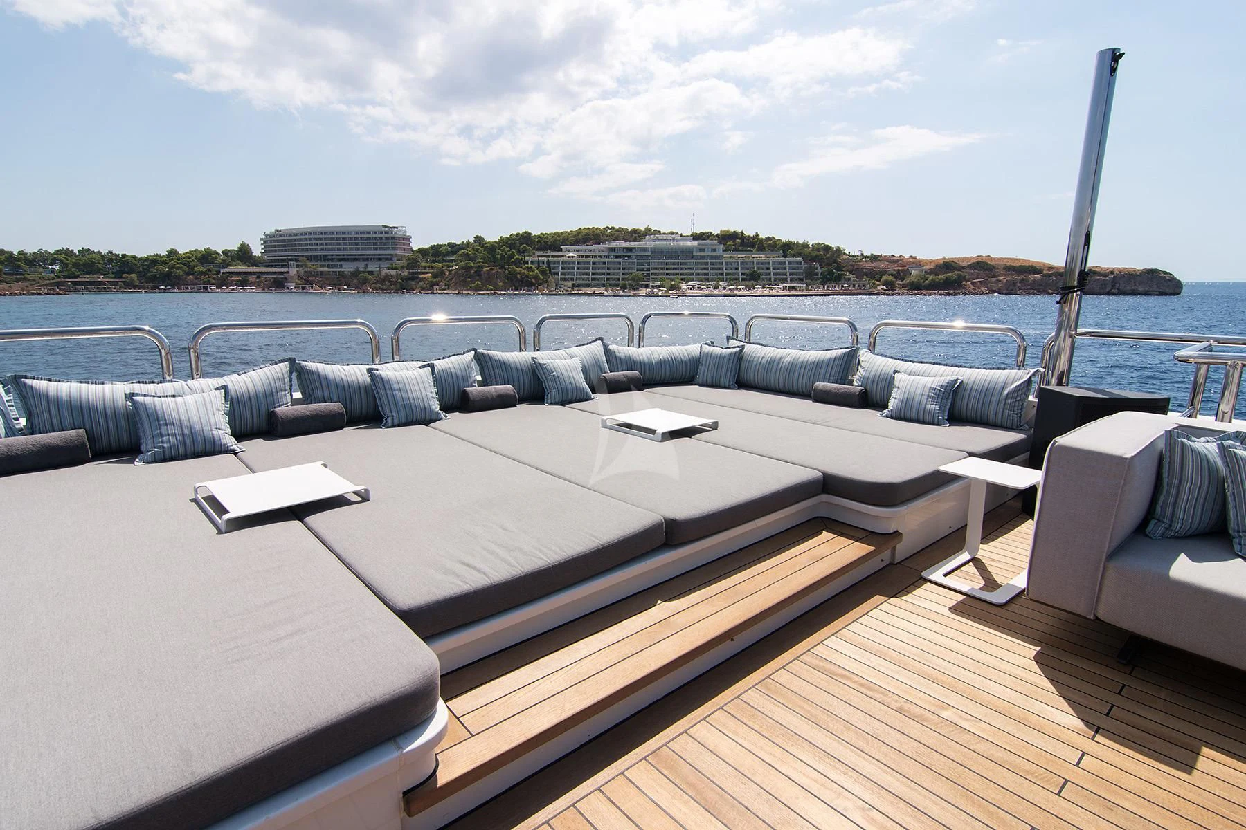 a large lounge chair on a deck overlooking a body of water aboard HALLO Yacht for Sale