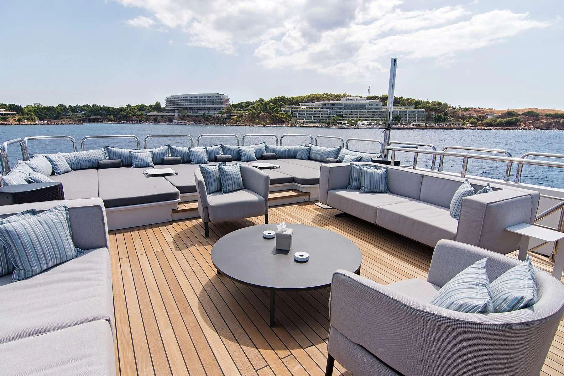 a deck with a table and chairs aboard HALLO Yacht for Sale