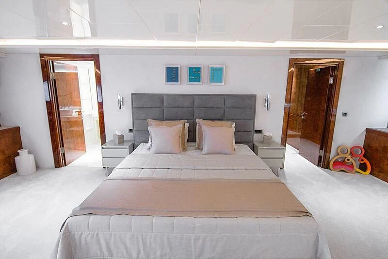 a bedroom with a bed and a door aboard HALLO Yacht for Sale