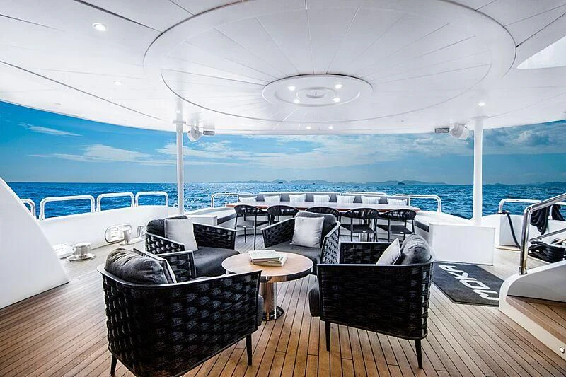a room with a table chairs and a view of the ocean aboard HALLO Yacht for Sale