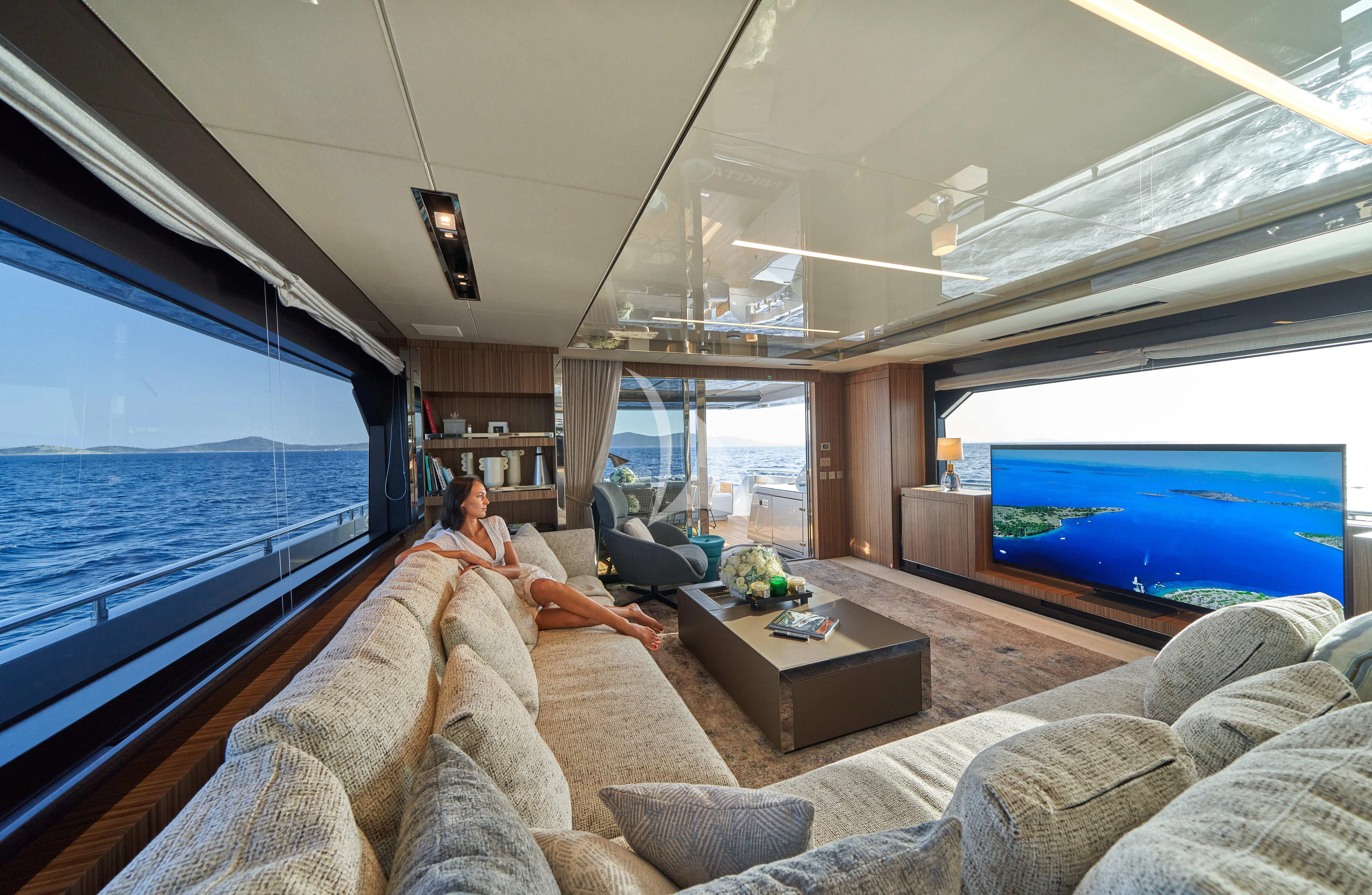 a group of people sitting in a room with a large window aboard NIKITA Yacht for Sale