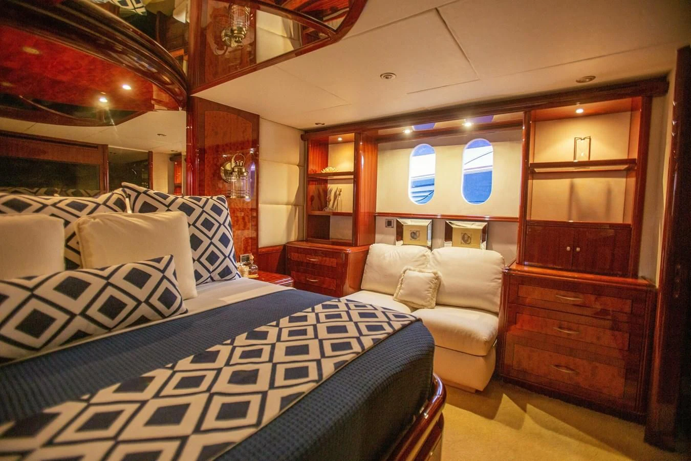 a bedroom with a bed and a mirror aboard LAZZARA 80' Yacht for Sale
