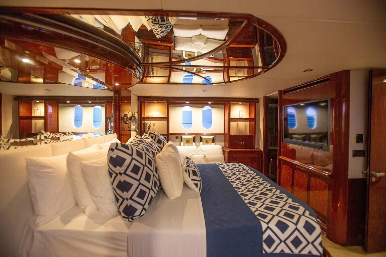 a room with a bed and a television aboard LAZZARA 80' Yacht for Sale