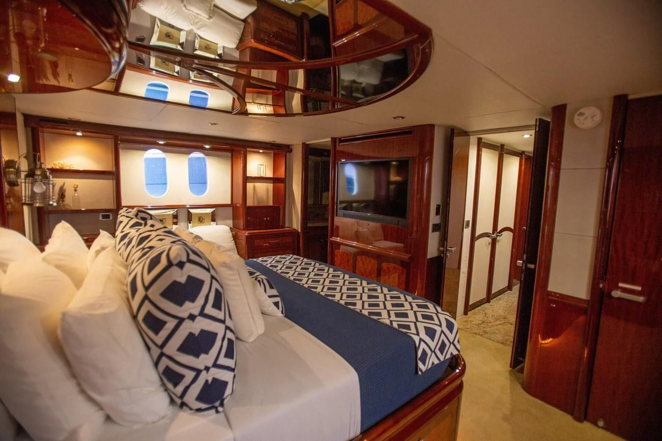 a room with a bed and a mirror aboard LAZZARA 80' Yacht for Sale