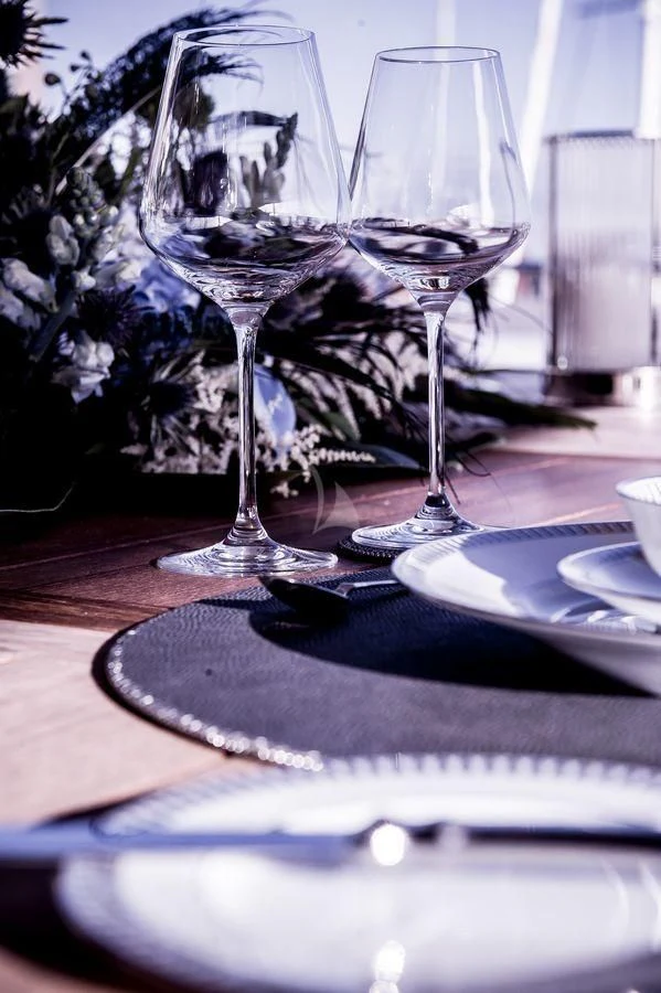 a couple of wine glasses on a table aboard AQUA LIBRA Yacht for Charter