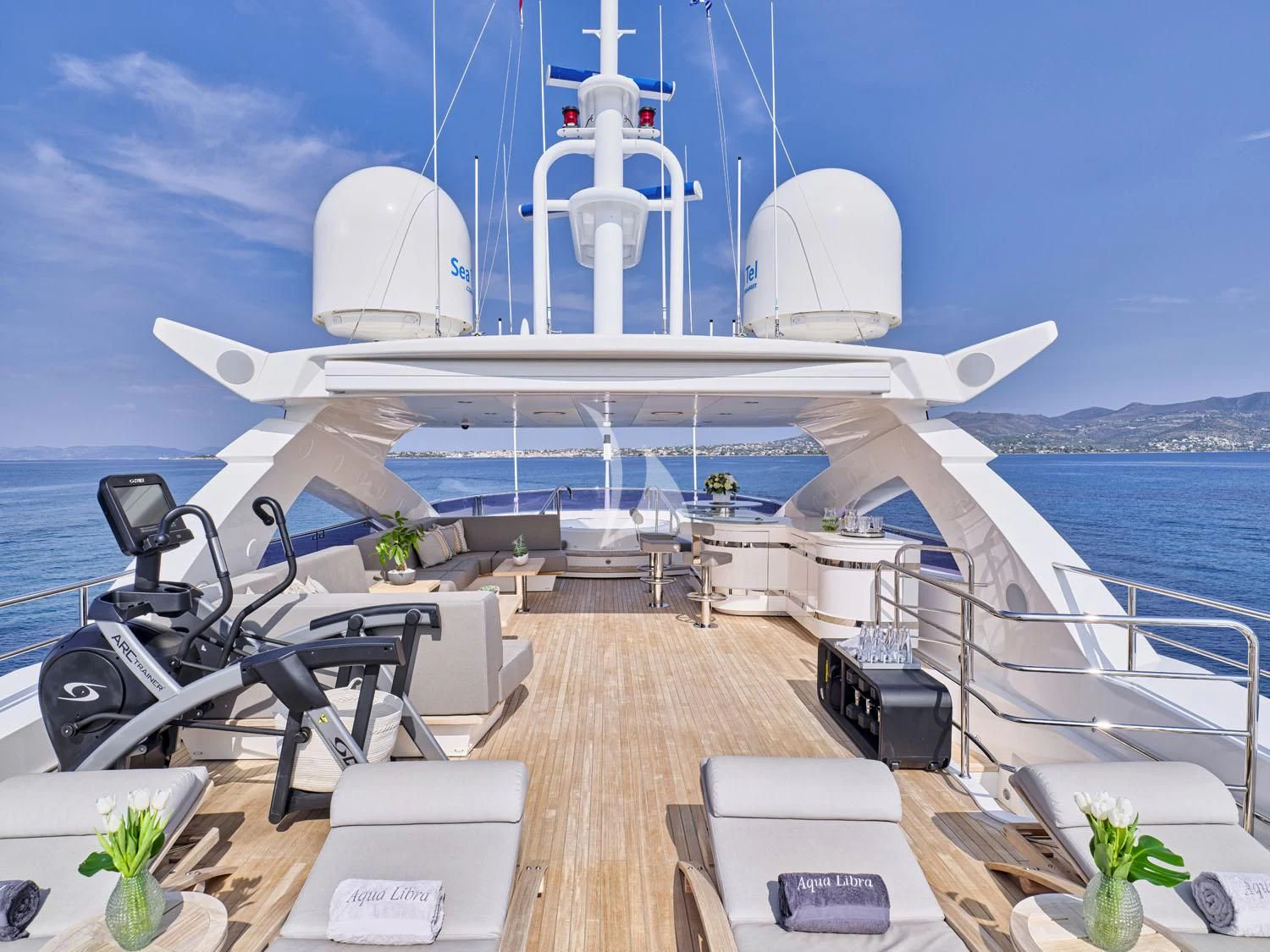 a deck with a large ship in the background aboard AQUA LIBRA Yacht for Charter