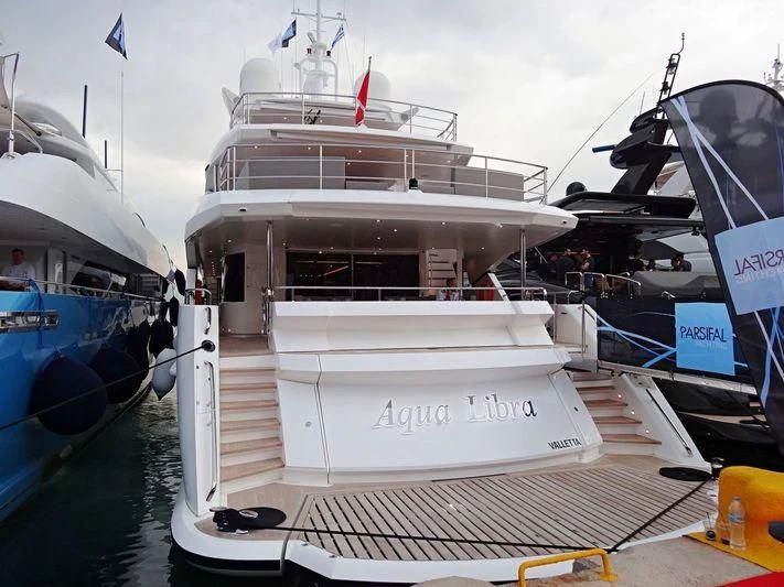 a large white boat with a smaller boat on it aboard AQUA LIBRA Yacht for Charter