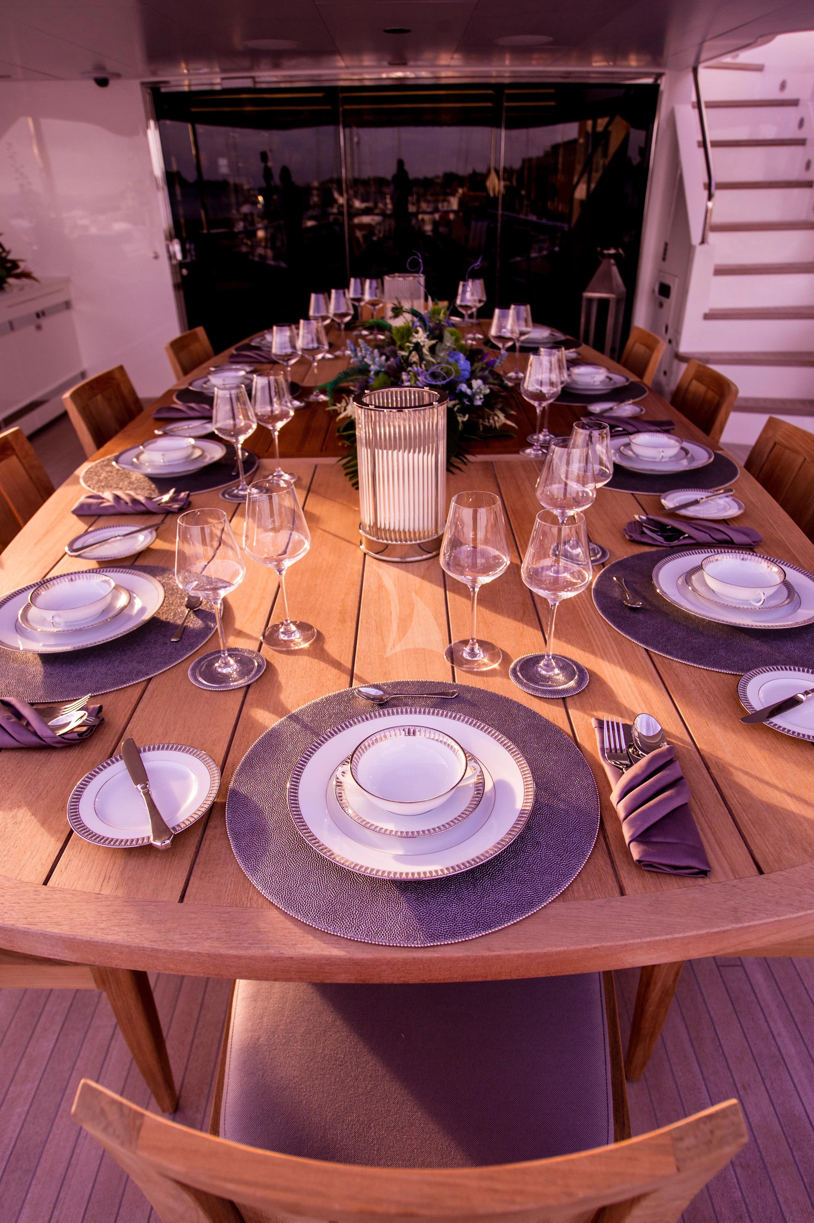 a table with plates and glasses on it aboard AQUA LIBRA Yacht for Charter