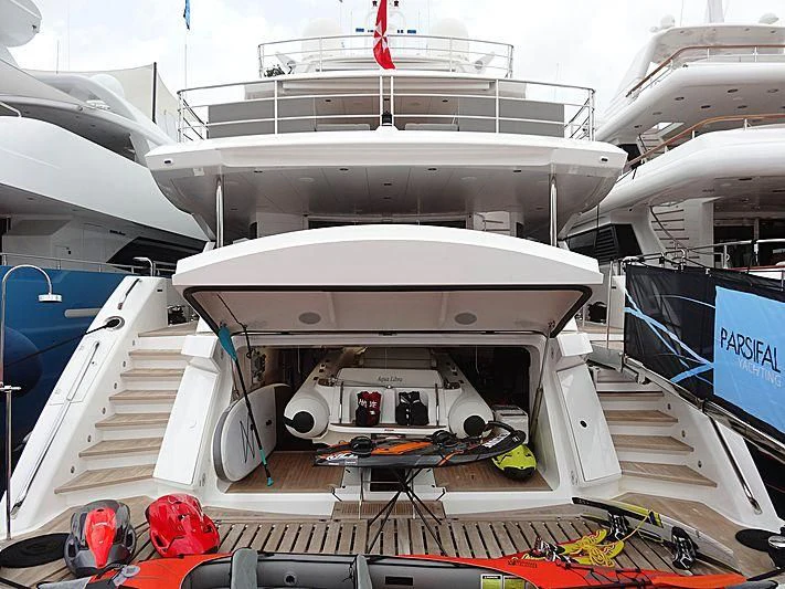 a large white boat with a few boats on it aboard AQUA LIBRA Yacht for Charter