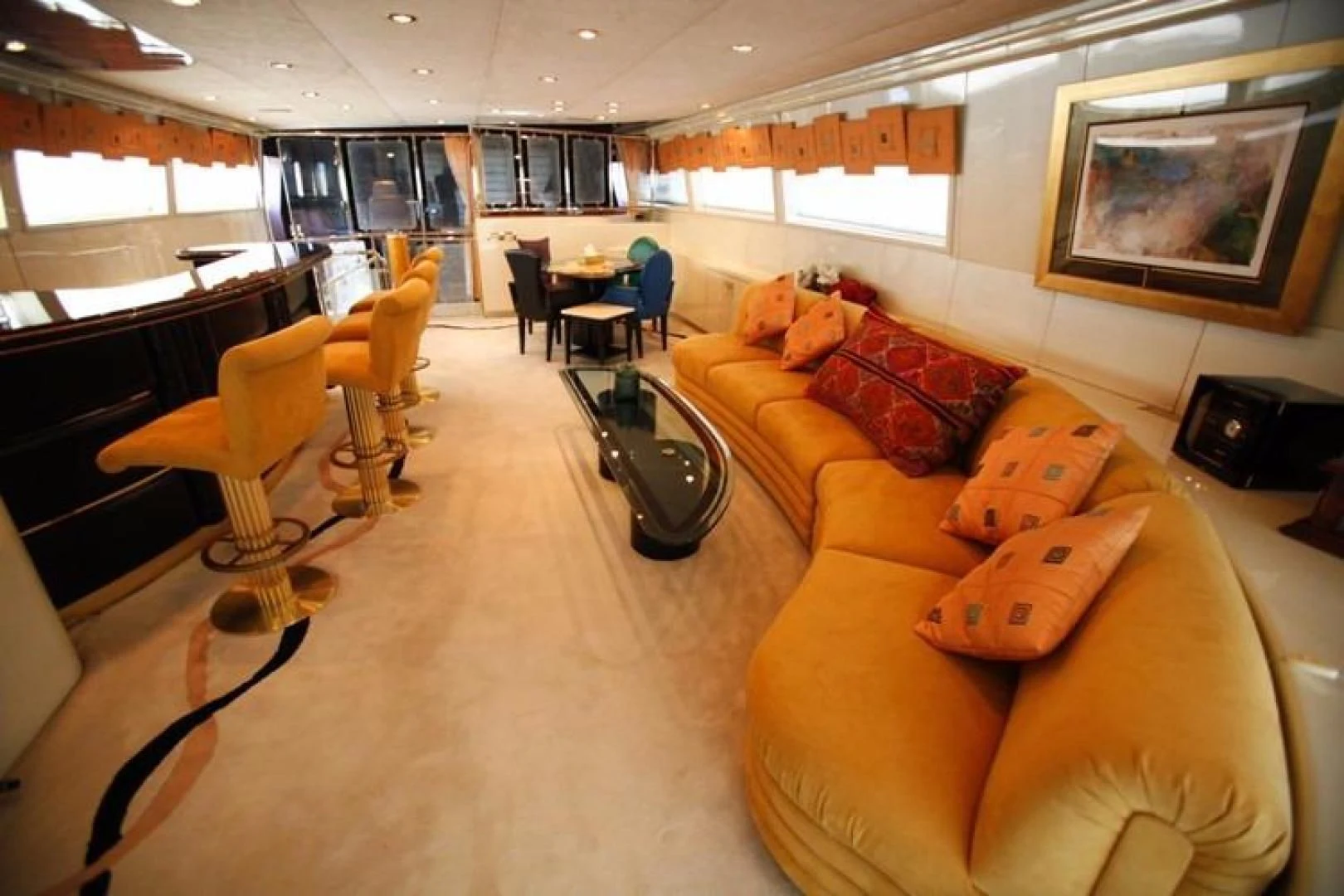 an empty living room with orange couches aboard TAMTEEN Yacht for Sale