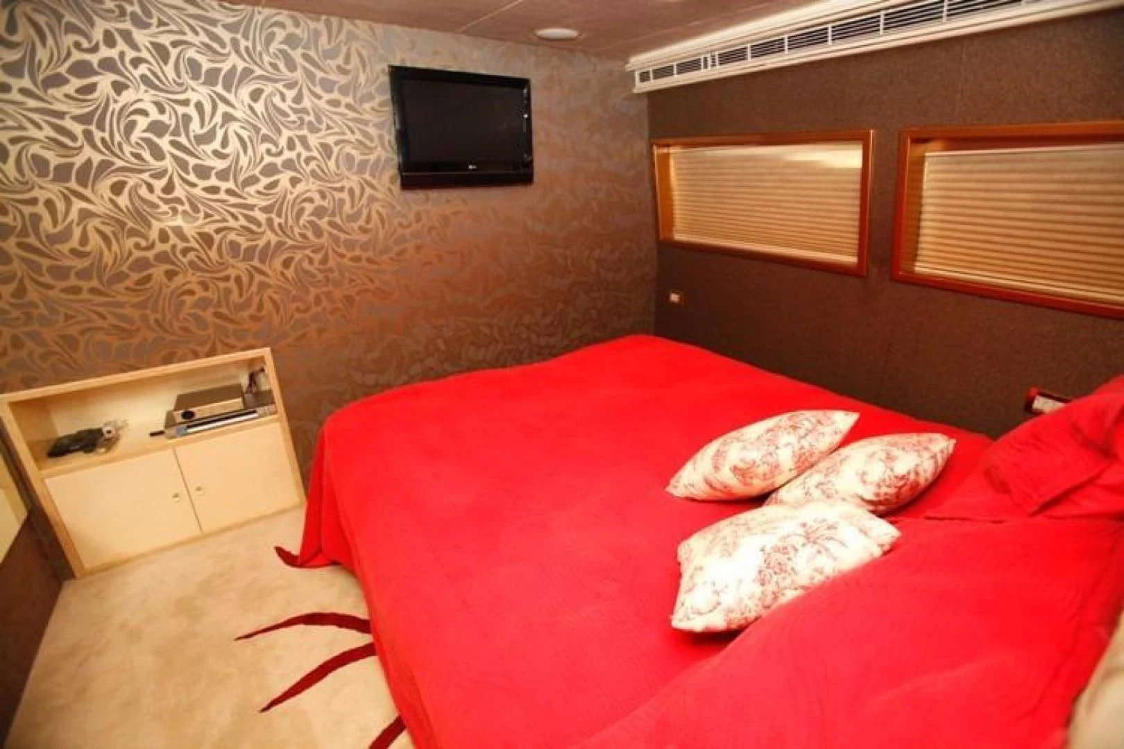 a bed with red sheets aboard TAMTEEN Yacht for Sale