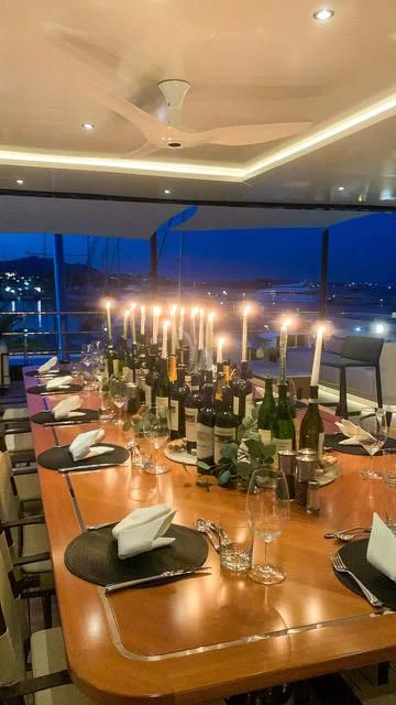 a table with wine glasses and bottles on it aboard CALEX Yacht for Sale