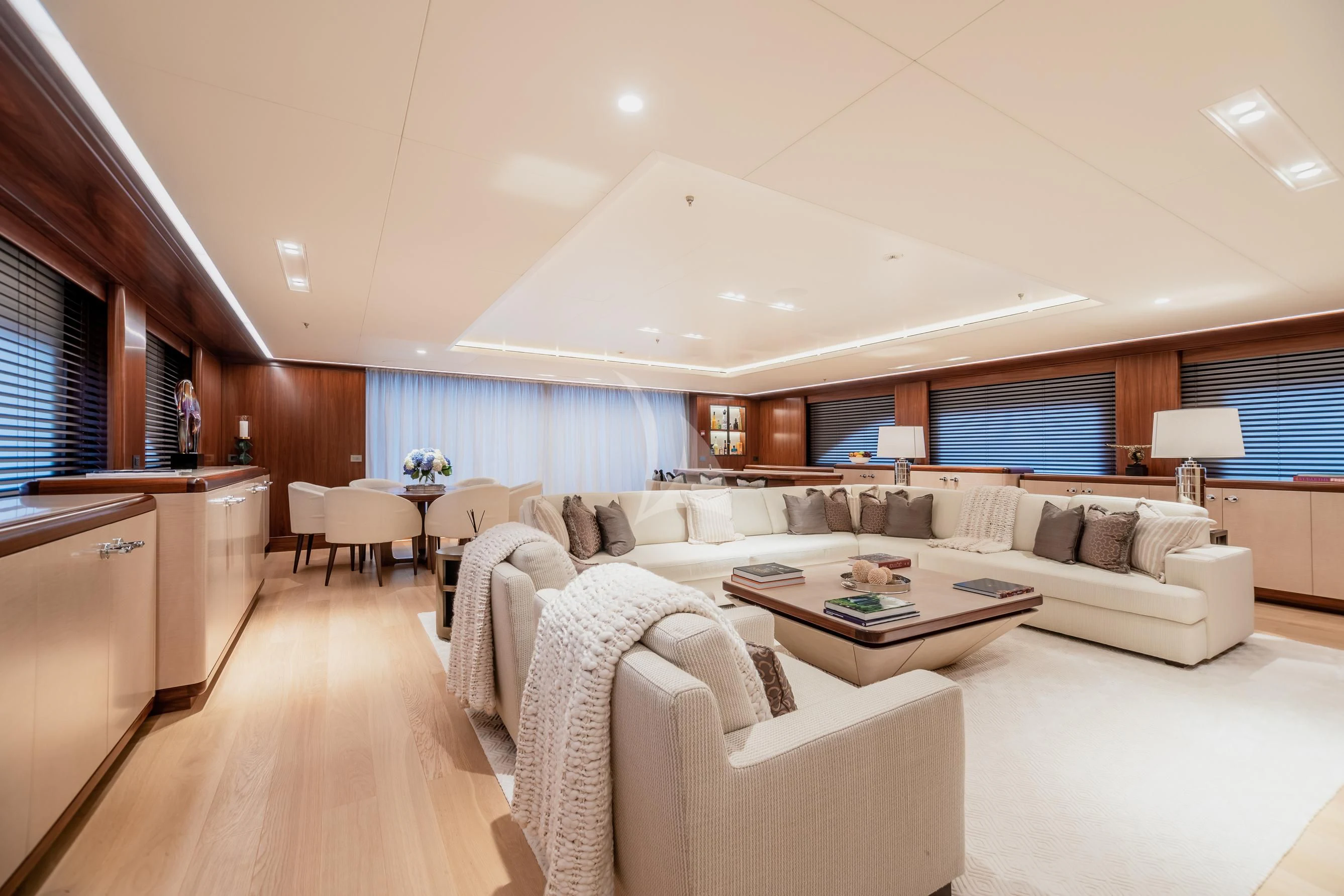 a large living room with a large white sofa and a large window aboard CALEX Yacht for Sale