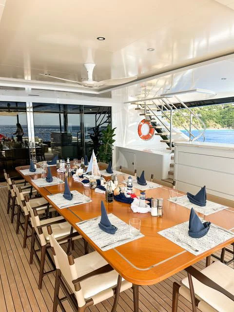a room with tables and chairs aboard CALEX Yacht for Sale