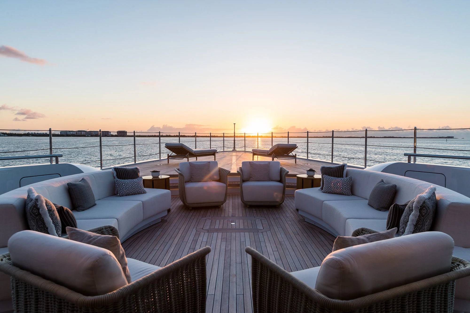 a patio with a large body of water and a large boat in the background aboard CALEX Yacht for Sale