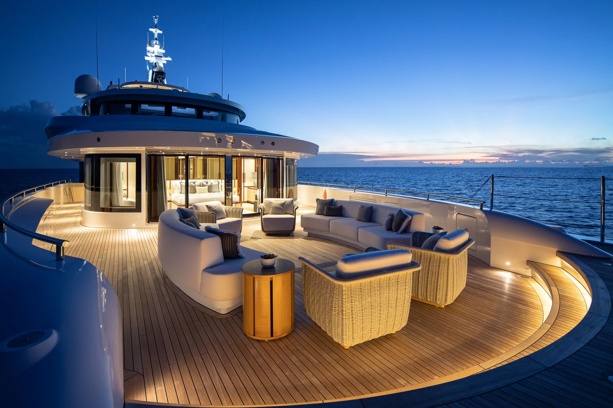a deck with a view of the ocean and a large boat in the background aboard CALEX Yacht for Sale