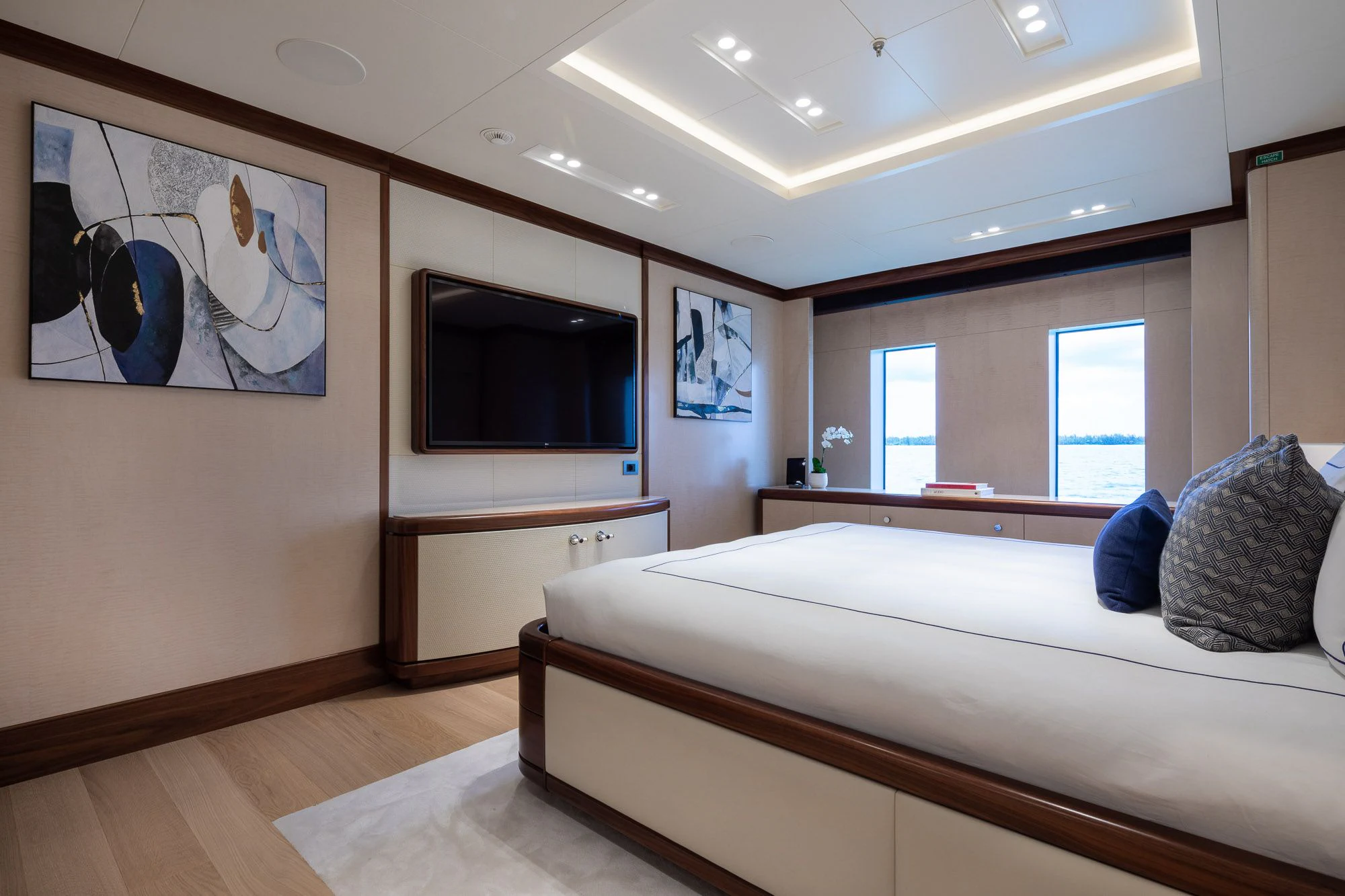 a bedroom with a bed and a tv on the wall aboard CALEX Yacht for Sale
