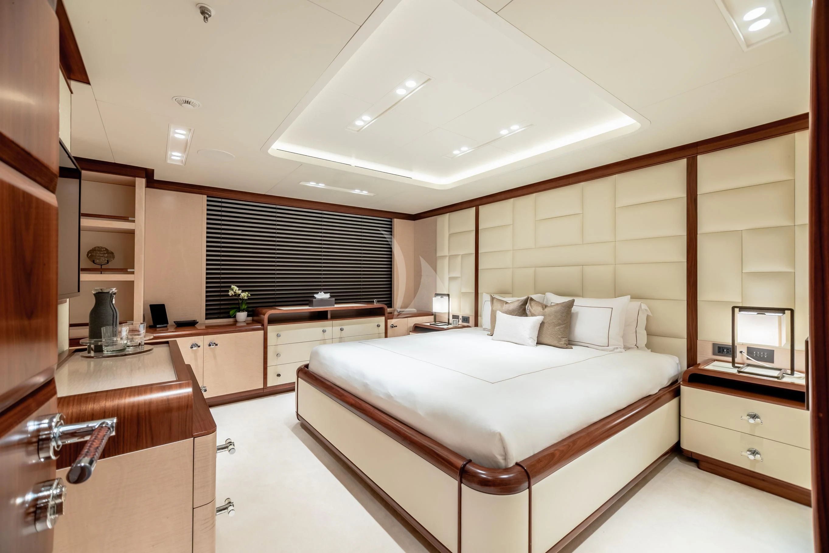 a bedroom with a bed and cabinets aboard CALEX Yacht for Sale