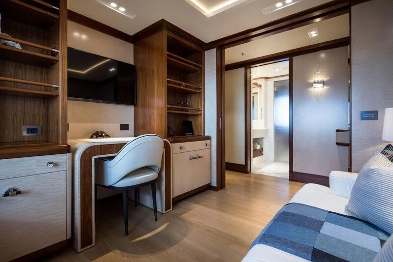 a bedroom with a bed and a desk aboard CALEX Yacht for Sale