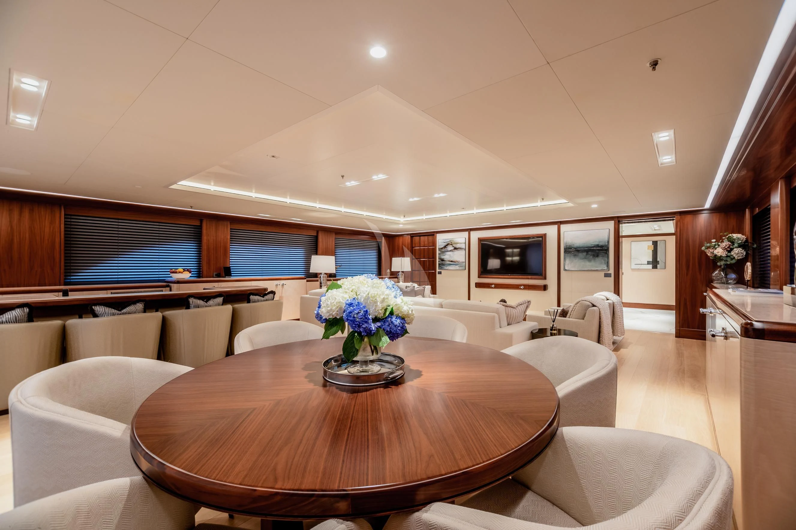a large room with a table and chairs aboard CALEX Yacht for Sale