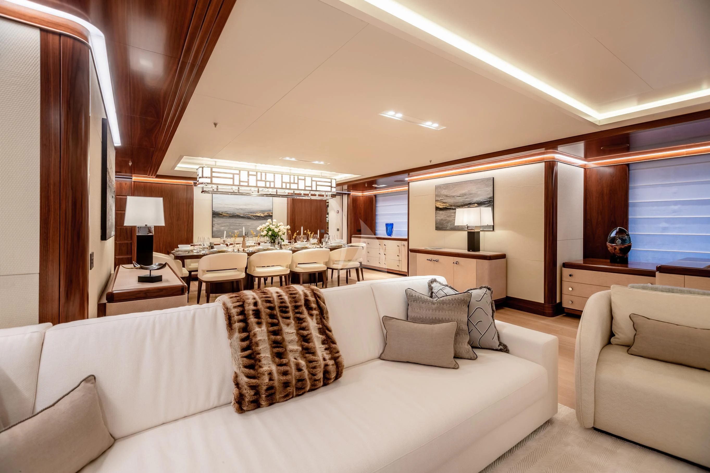 a living room with a large white couch and a large window aboard CALEX Yacht for Sale