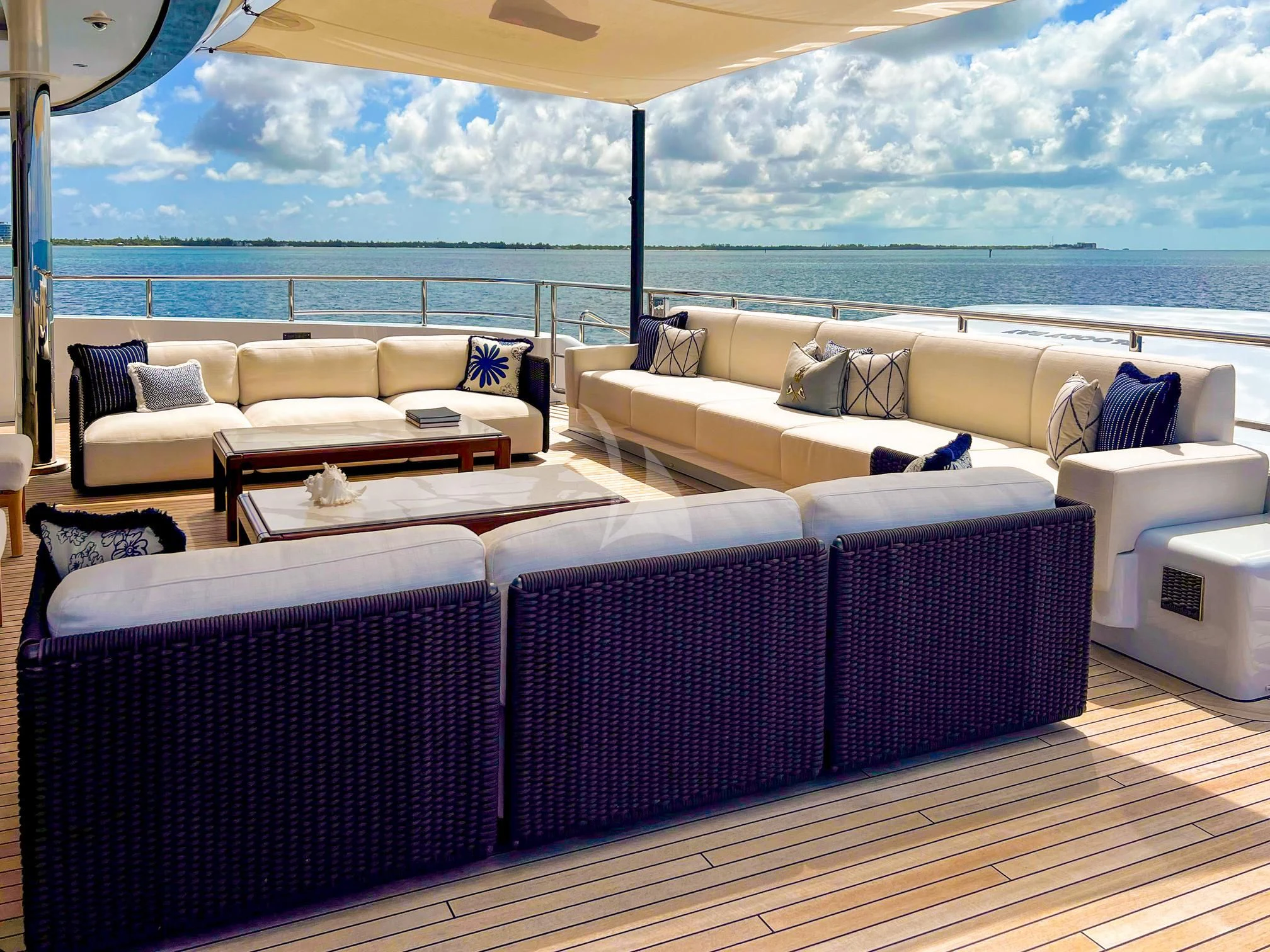 a room with a couch and a table with a view of the ocean aboard CALEX Yacht for Sale