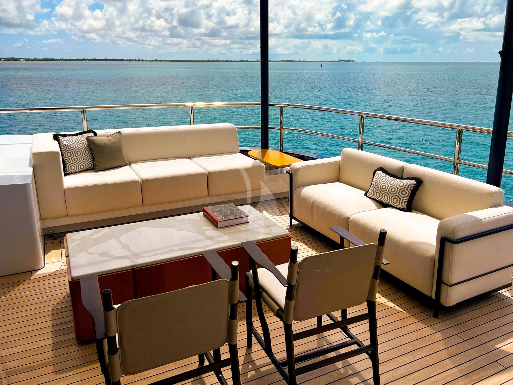 a table and chairs on a deck overlooking a body of water aboard CALEX Yacht for Sale