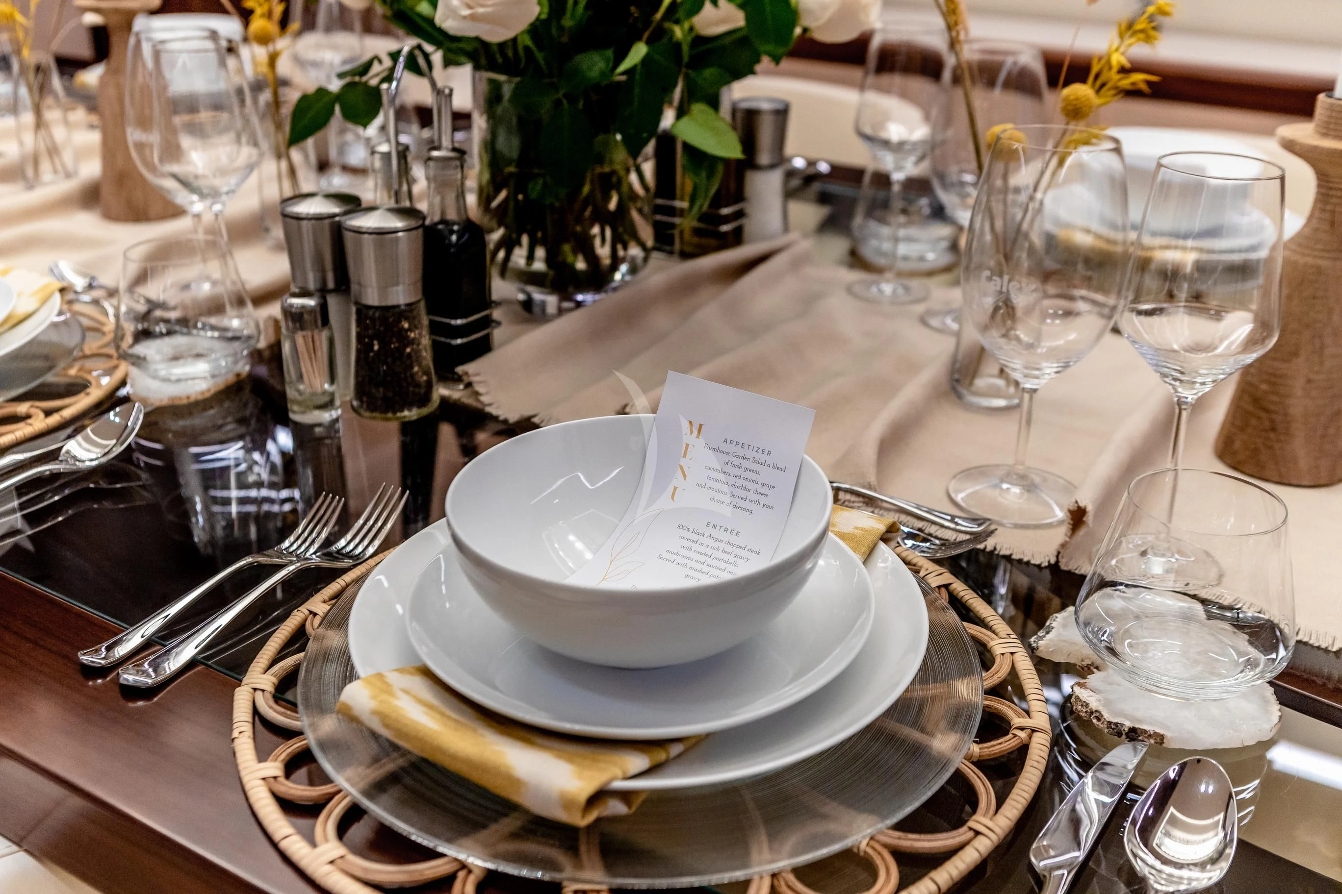 a table with plates and glasses aboard CALEX Yacht for Sale