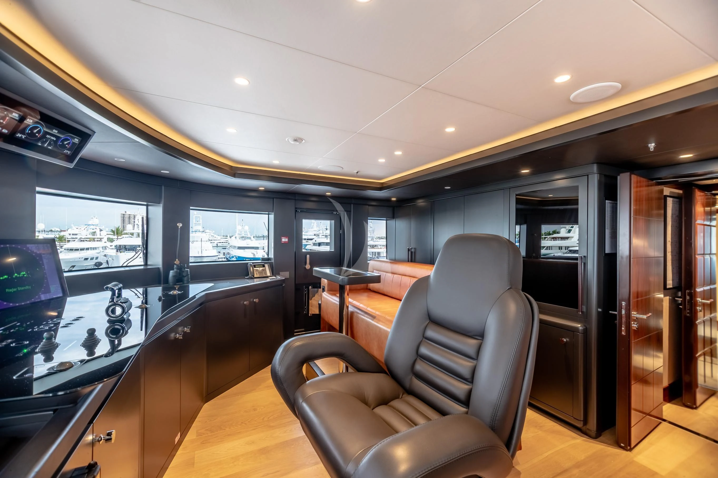 inside of a building with a large window and a table with chairs and a computer on it aboard CALEX Yacht for Sale