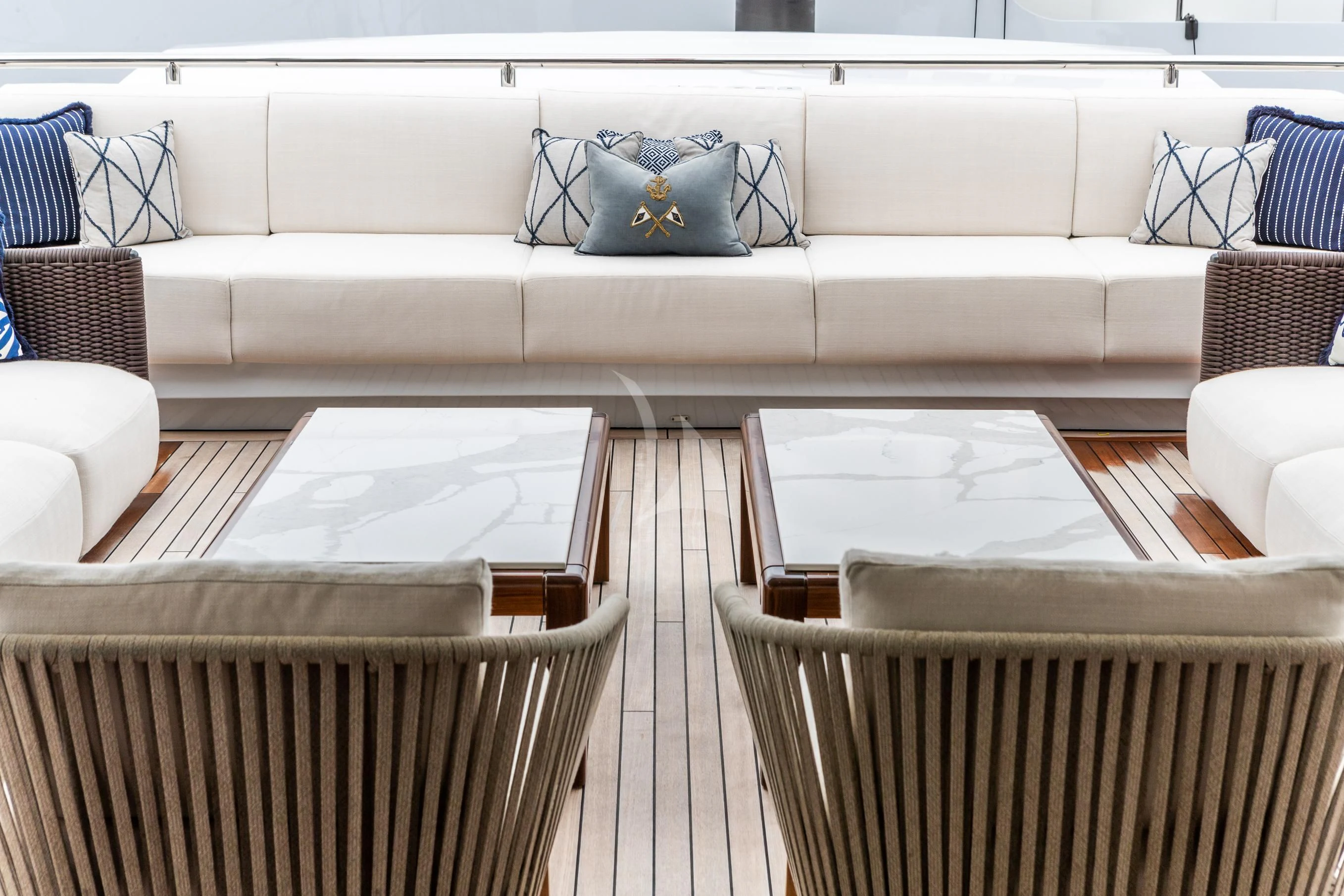 a white couch with a blue pillow on it aboard CALEX Yacht for Sale