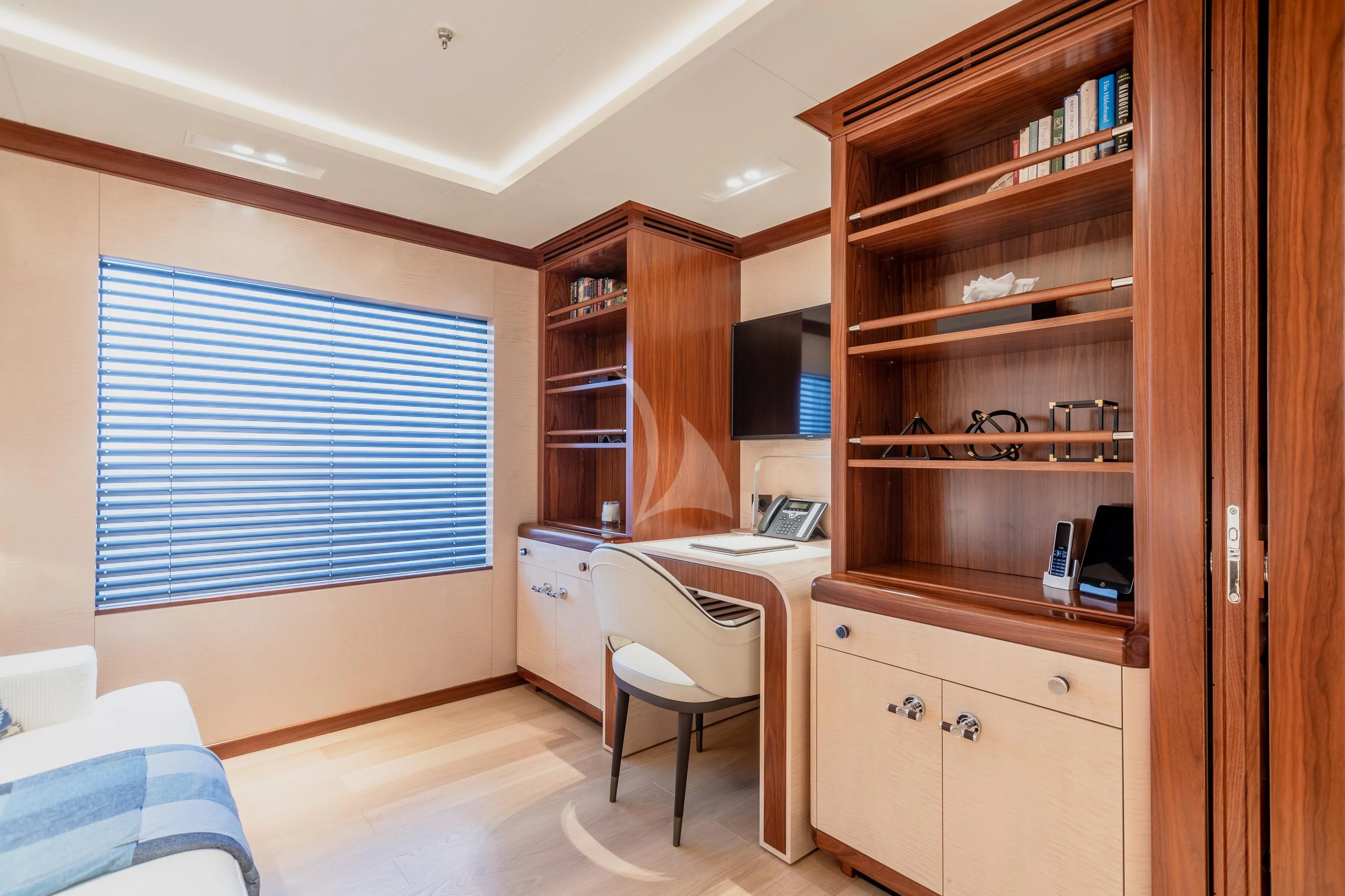 a room with a desk and a shelf with books aboard CALEX Yacht for Sale