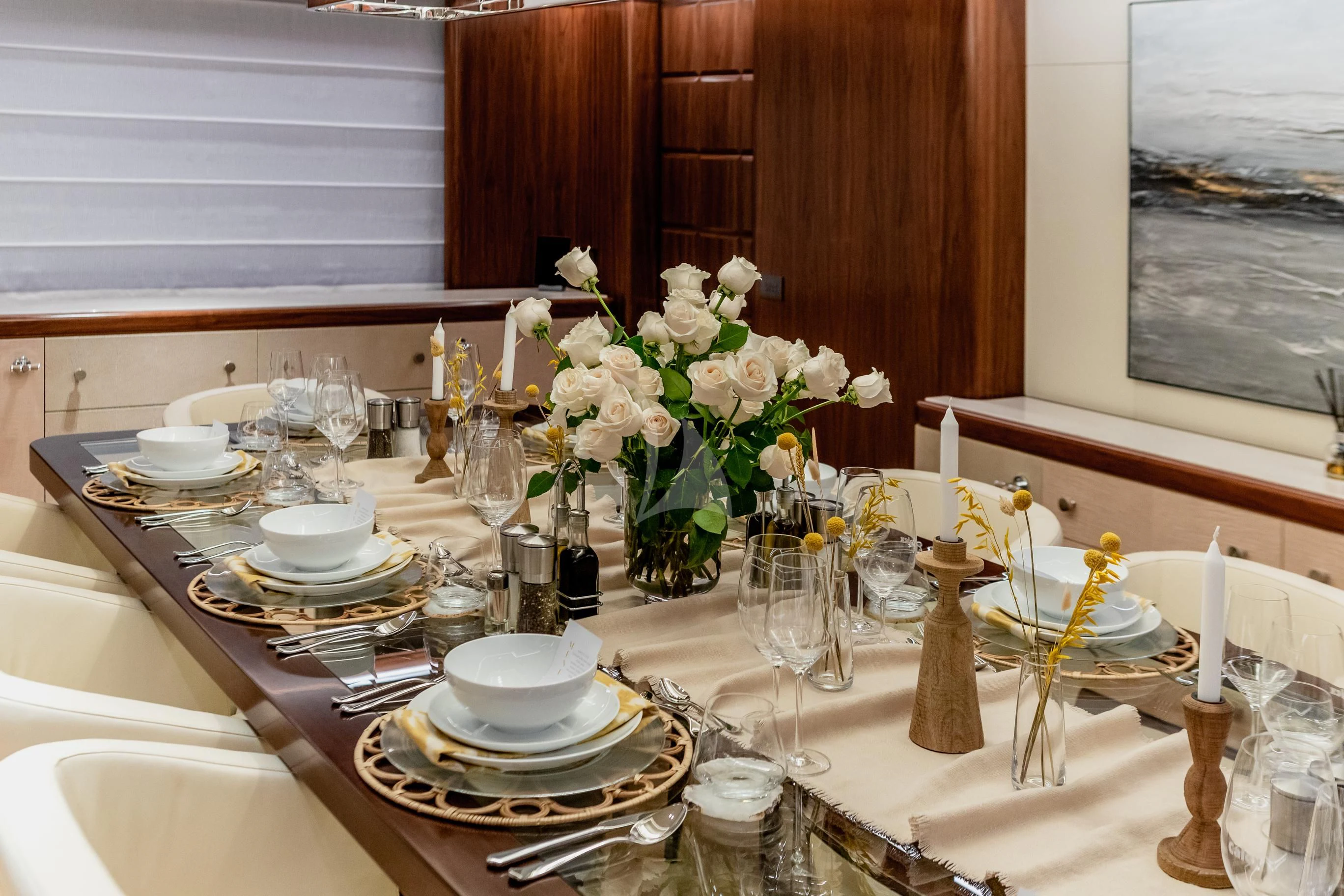 a table set with plates and flowers aboard CALEX Yacht for Sale