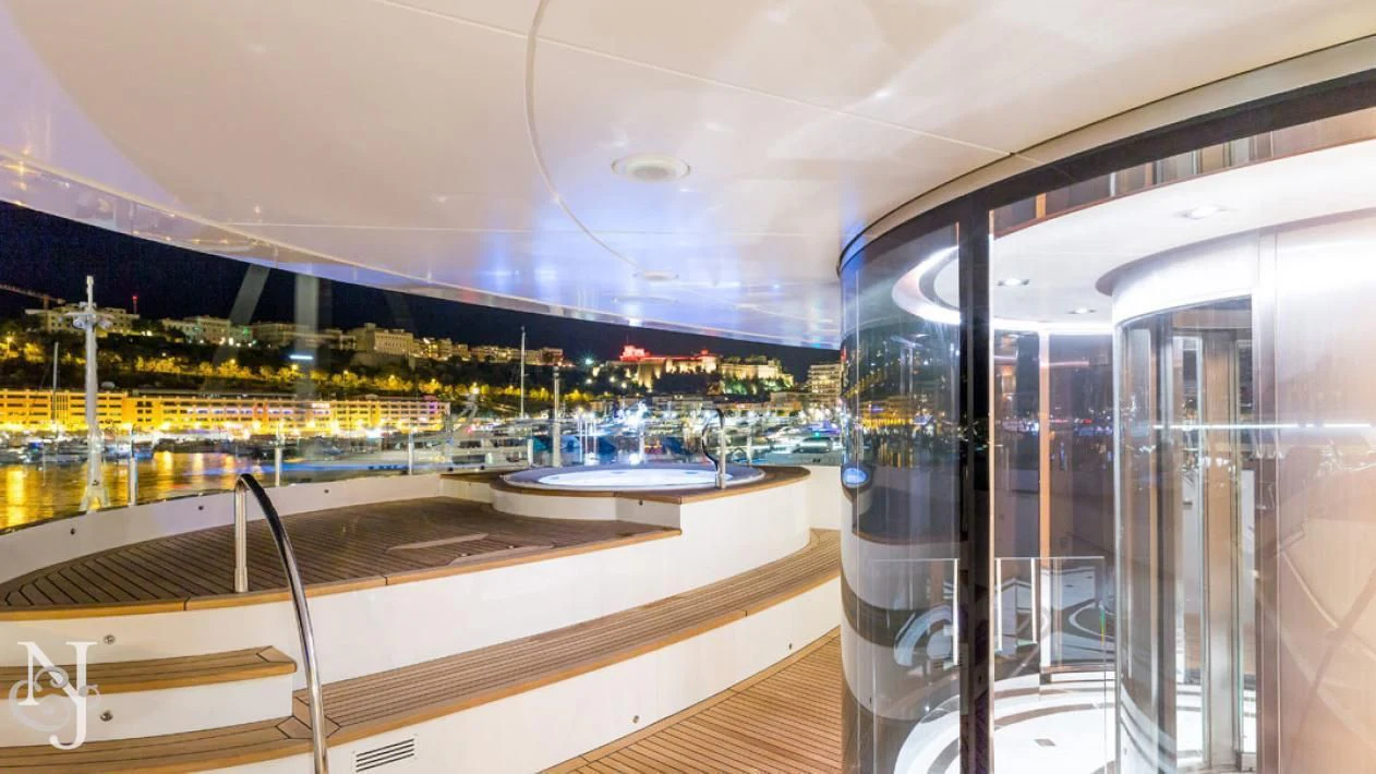 a room with glass walls and a view of a city aboard MAYBE Yacht for Sale