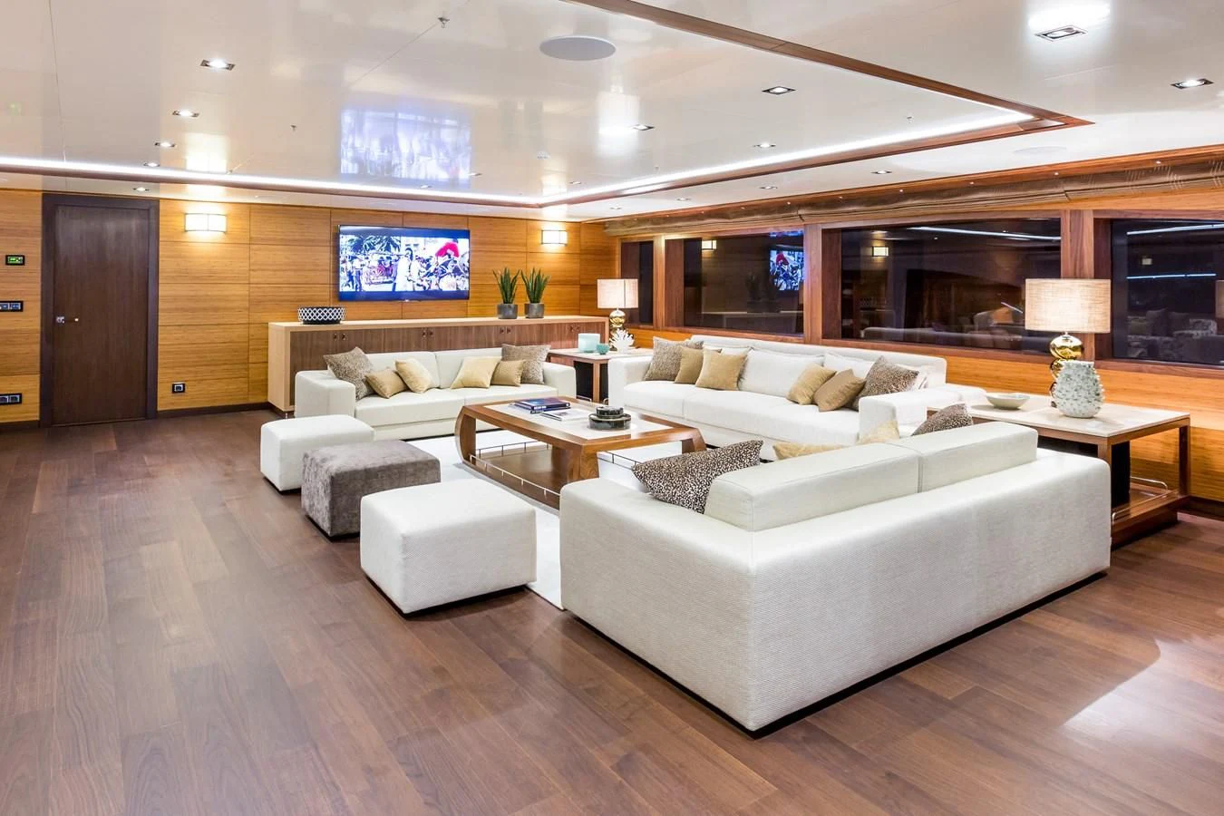 a living room with a large white couch and a large window aboard MAYBE Yacht for Sale