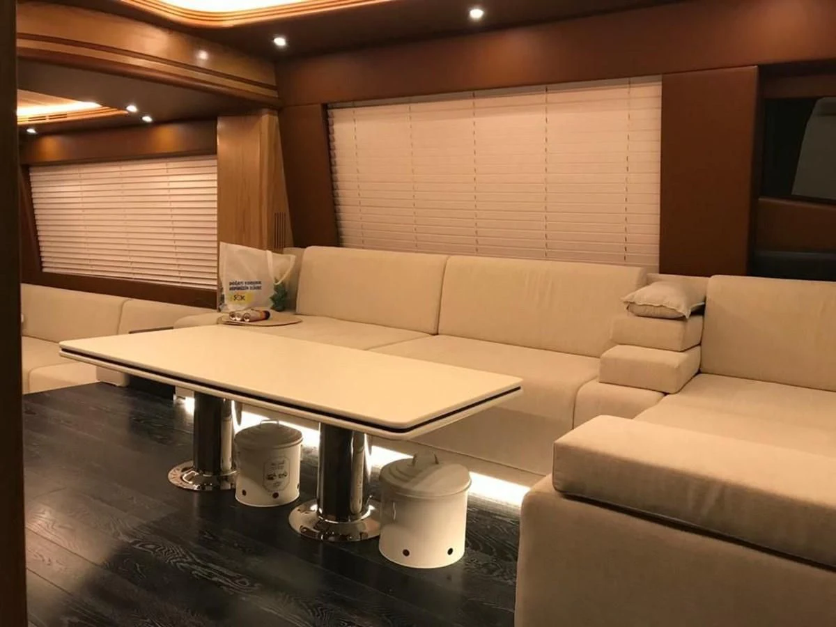 a living room with a couch and coffee table aboard AZIMUT 100/32 Yacht for Sale