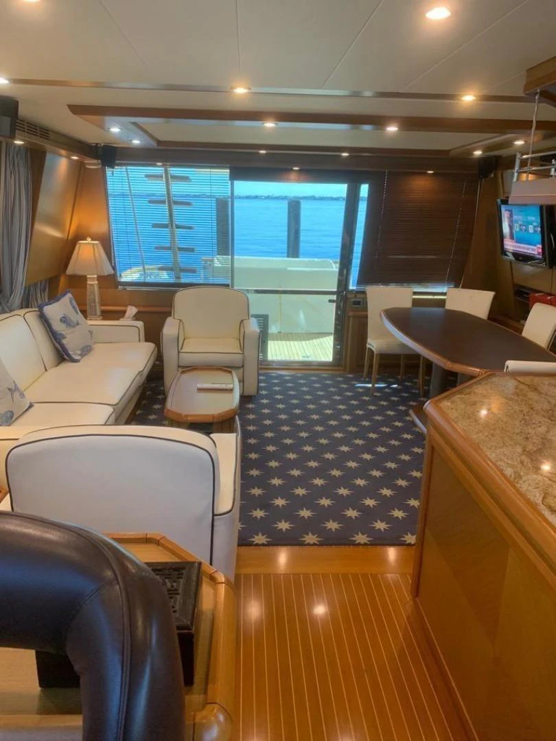 a room with a large window and a table with chairs and a tv aboard KNOT NANNY'S Yacht for Sale