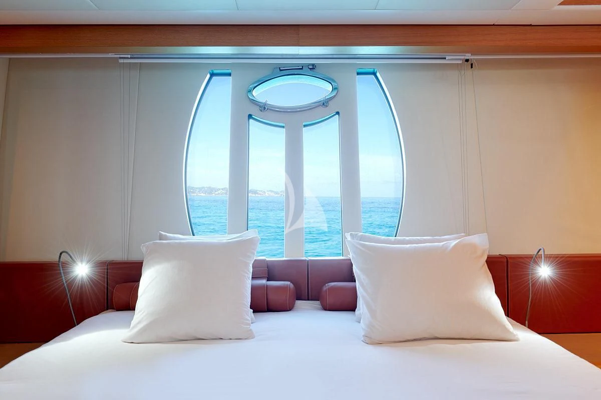 a bed with pillows and a window aboard WAHOO Yacht for Sale