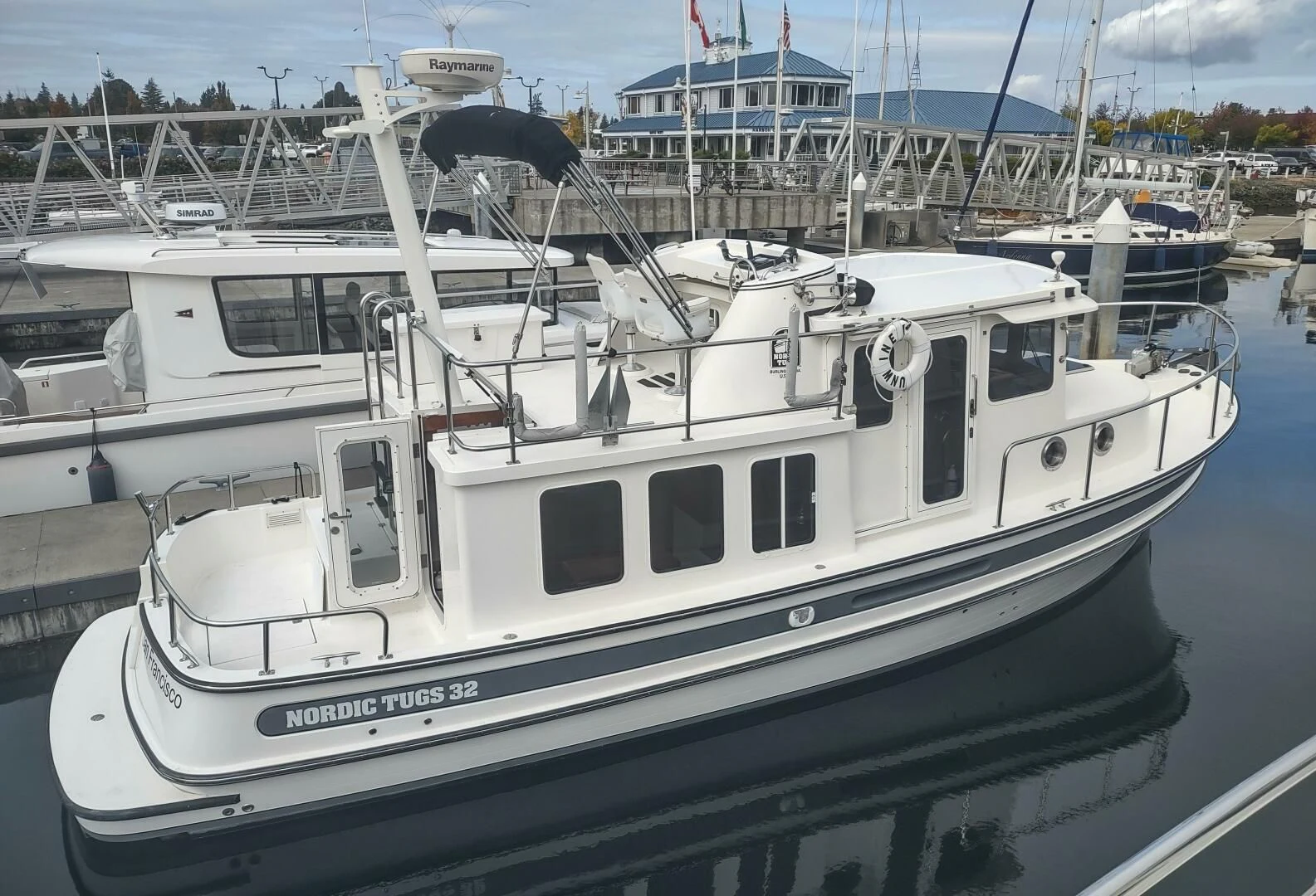 a white boat in a harbor aboard UNWINED Yacht for Charter
