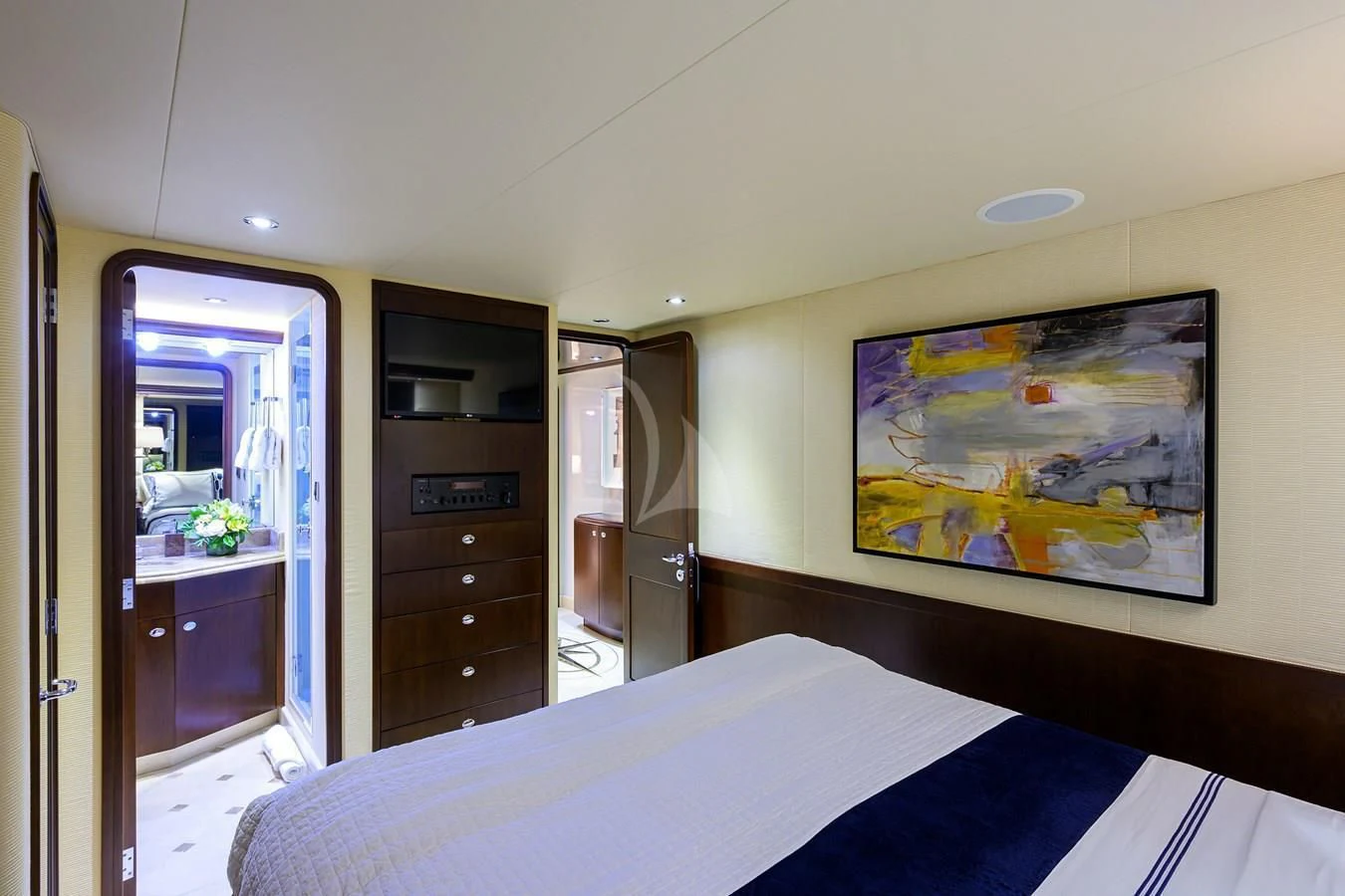 a bedroom with a bed and a painting on the wall aboard UNWINED Yacht for Charter