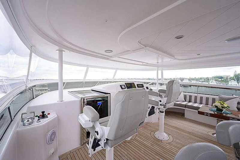 a room with a large white chair and a table with chairs aboard UNWINED Yacht for Charter
