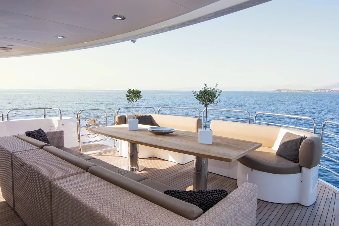 a table and chairs on a deck overlooking a body of water aboard PATHOS Yacht for Sale