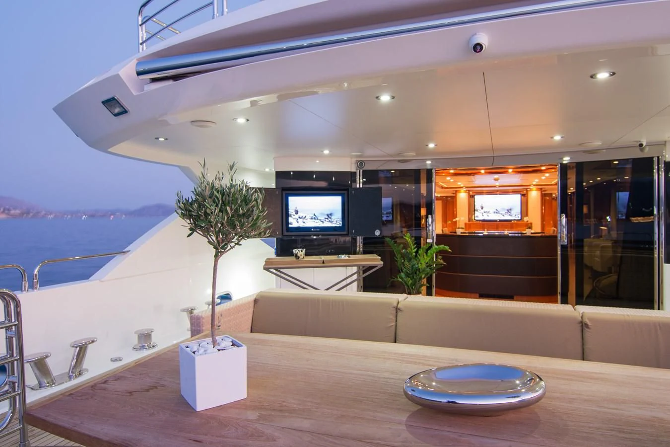 a room with a table and a tv aboard PATHOS Yacht for Sale