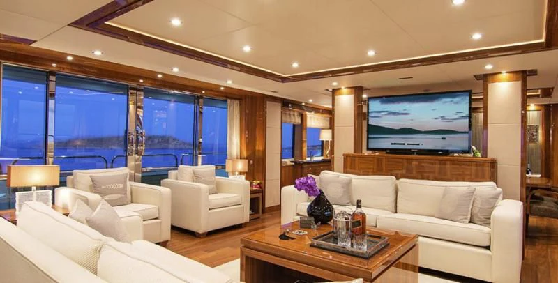 a living room with a large screen aboard PATHOS Yacht for Sale