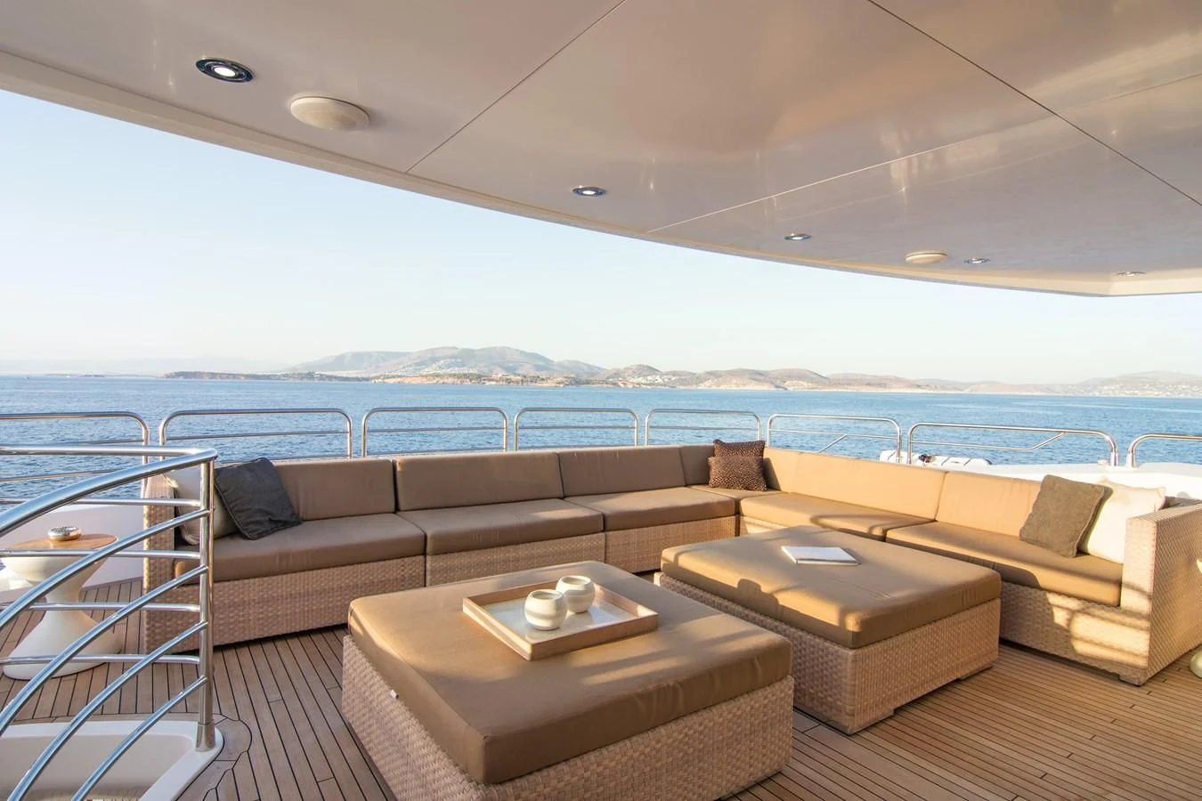 a couch and a table in a room with a view of the ocean aboard PATHOS Yacht for Sale