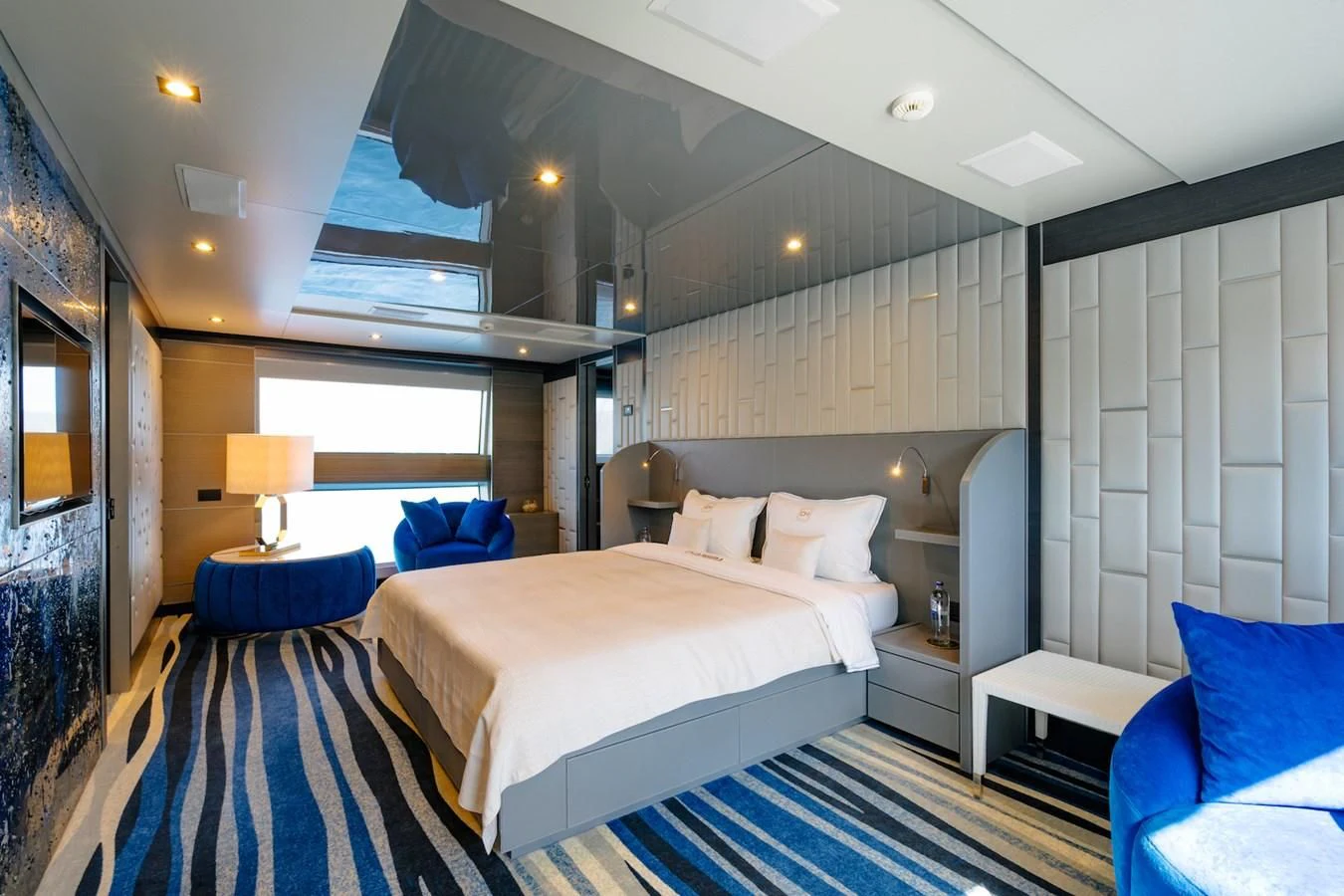a room with a bed and a blue couch aboard CHARISMA Yacht for Sale