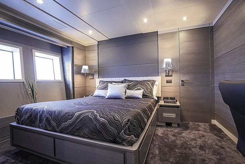 a bedroom with a bed and a chair aboard CHARISMA Yacht for Sale
